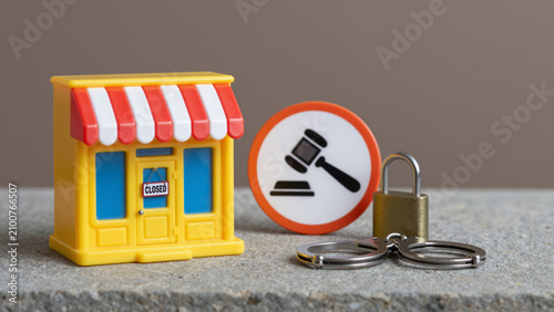 Store Closure and Legal Action Concept – Miniature Yellow Storefront with Closed Sign and Gavel Symbol on Stone Surface for Business Shutdown, Asset Seizure, and Commercial Dispute Illustrations