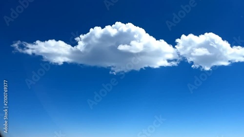 Beautiful white clouds floating serenely against a vibrant, clear, and bright blue sky on a sunny day