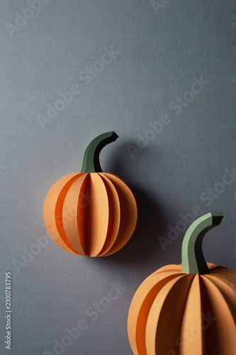 Minimal autumn pumpkins in paper cut style on dark background – seasonal 3D illustration, AI generated