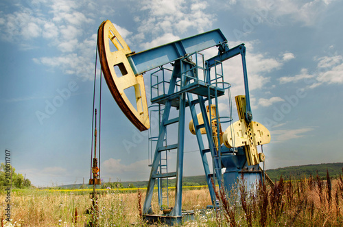 Oil Pumpjack in Rural Landscape Under Dramatic Clouds