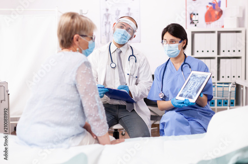 Foto Specialist doctor and nurse present a diagnosis to a senior woman on a tablet computer during a health safety consultation in a medical office