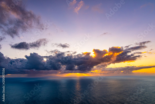 Obraz na płótnie Dramatic sunrise over the Atlantic Ocean with sun rays shining through heavy clo