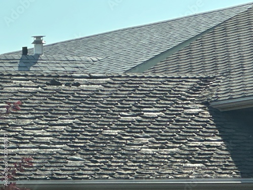 Aged and Worn Shingles Visible on Residential Roof Requiring Maintenance