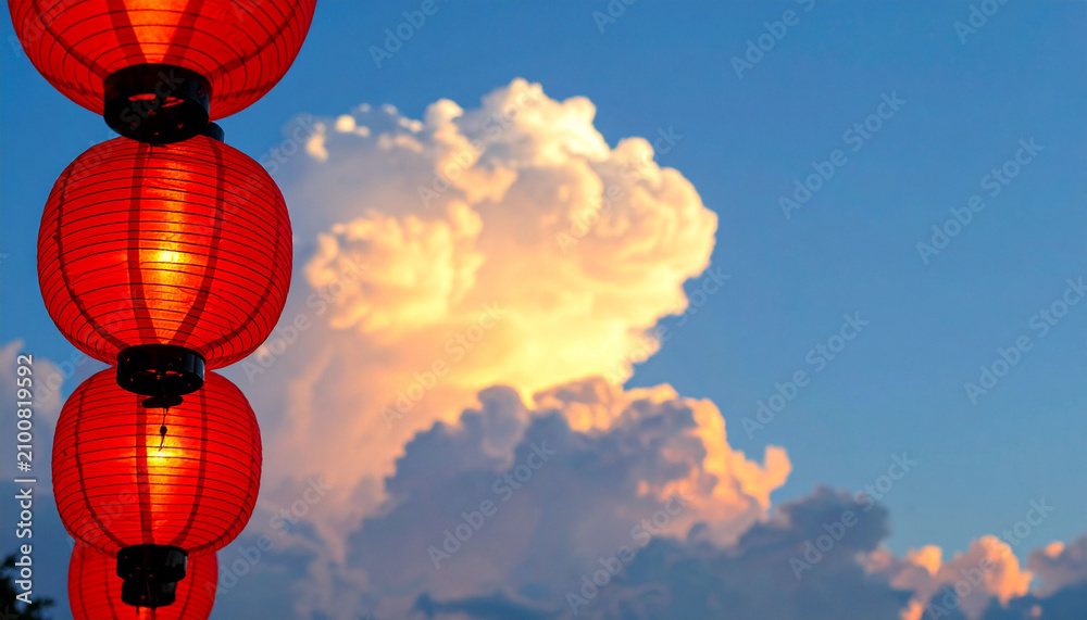 Fototapeta premium 青空と夕暮れの入道雲を背景にした赤い提灯の並び 中華街や祭りの雰囲気を演出するコピースペース付きの情緒的な風景写真 お祝いや旅行のイメージに活用できるアジア風の壁紙背景素材