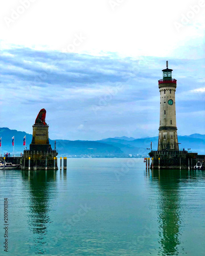 Scenic Lindau harbor entrance with the historic lighthouse and Bavarian Lion statue on Lake Constance, Germany.