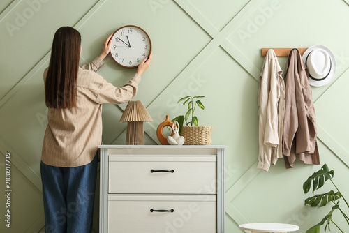 Woman hanging a round wall ...