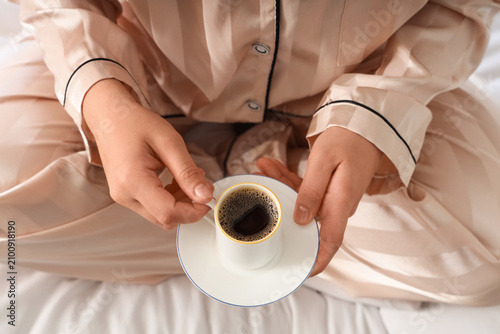 Person in silk pajamas hold...
