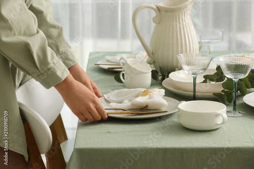 Woman setting a dining tabl...