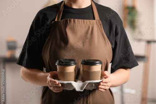 Barista in a brown apron ho...
