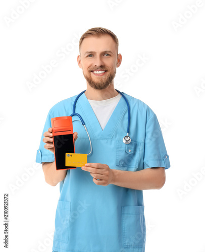Male doctor with payment terminal and credit card on white background