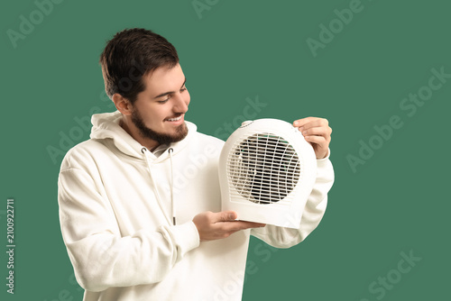 Young man with electric fan...