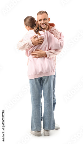 Young couple in hoodies hug...