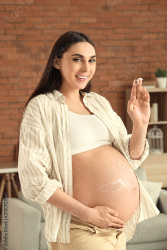 Young pregnant woman applyi...