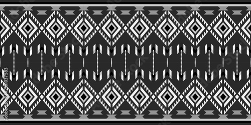Monochrome tribal-inspired geometric seamless pattern with layered diamonds, arrow motifs, chevrons, and bold horizontal bands for textile, fashion, wallpaper, and surface design.
