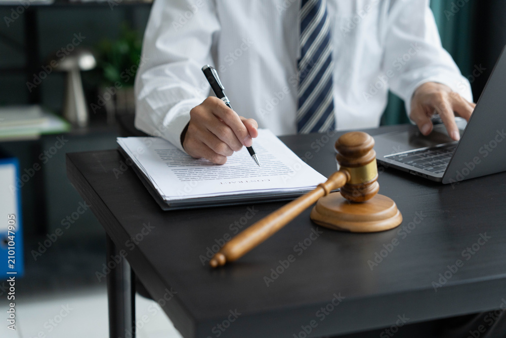 Fototapeta premium Lawyer checking documents and typing on laptop