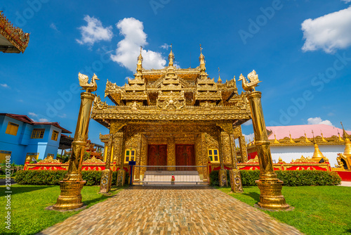 Foto Grand golden pavilion architecture with ornate pillars under a blue sky at Wat Thai Wattanaram temple in Mae Sot, Tak, Thailand