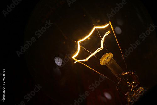 Foto glowing star filament incandescent light bulb illuminated against a dark background
