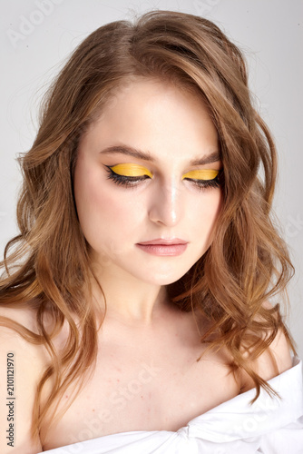 A beautiful female portrait with perfect makeup is depicted on a white background.