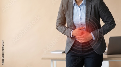 Businesswoman with stomach pain in office