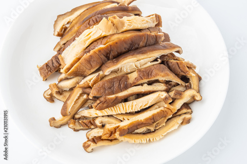 A dish of sliced ​​shiitake mushrooms on a white background.