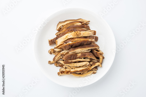 A dish of sliced ​​shiitake mushrooms on a white background.