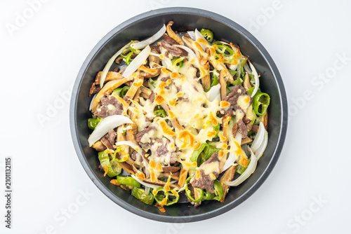 A plate of roasted beef with green peppers and onions