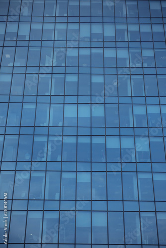 Modern glass office building. Blue glass skyscraper. Urban business tower facade. Architecture design. Reflective office windows background. Corporate office building. Urban architecture texture.