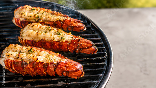 Three fresh lobster tails seasoned and cooking on a barbecue grill