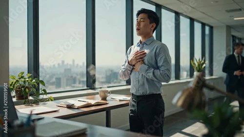 A businessman is taking a moment to himself in a modern office, with a panoramic view of the city skyline outside the window.