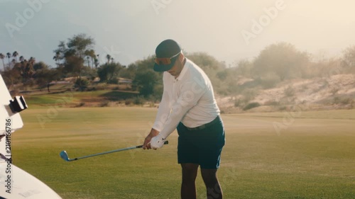 Scratch golfer hits wedge toward the green with perfect glowing divot on desert mountain course at sunset, captured in slow motion, suited to short-game tips and resort marketing.