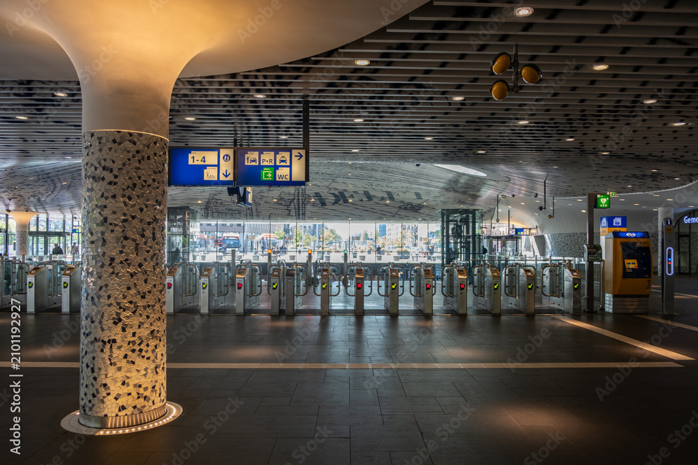 Obraz premium Ticket barriers and signage in modern Rotterdam Centraal Railway Station concourse, Rotterdam. Netherlands
