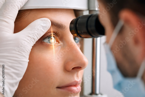 Ophthalmologist examining a patient eye with slit lamp during modern vision care consultation