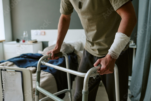 Foto Cropped shot of man using walker in military hospital, recovering from arm injury and mobility challenge