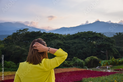Cuadro en lienzo Woman yellow outfit admiring mountain landscape during sunset colorful flower fi