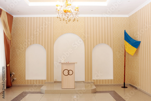 Schilderij op canvas Bright ceremonial wedding registration hall with podium, Ukrainian flag, chandelier and elegant classic interior