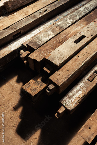 High angle view of stacked reclaimed timber beams with traditional joinery details.