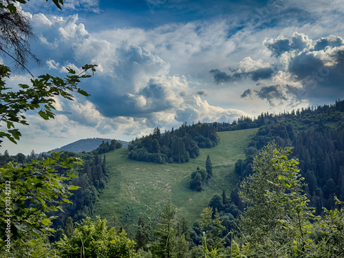 Sunny Carpathian peaks: green valleys and cloudy skies.
