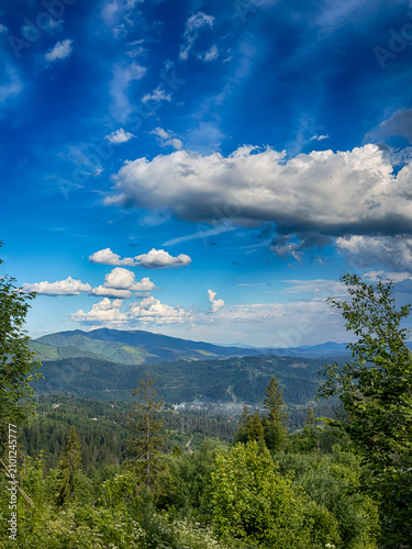 Sunny Carpathian peaks: green valleys and cloudy skies.