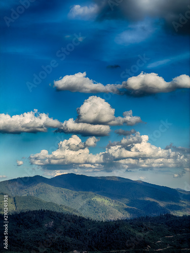 Sunny Carpathian peaks: green valleys and cloudy skies.