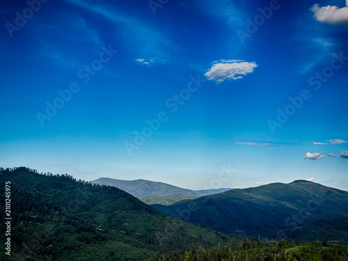 Sunny Carpathian peaks: green valleys and cloudy skies.