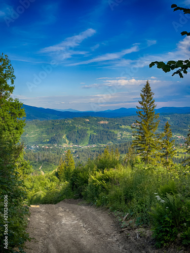 Sunny Carpathian peaks: green valleys and cloudy skies.