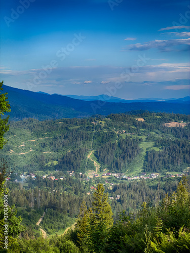 Sunny Carpathian peaks: green valleys and cloudy skies.