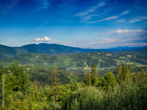 Sunny Carpathian peaks: green valleys and cloudy skies.