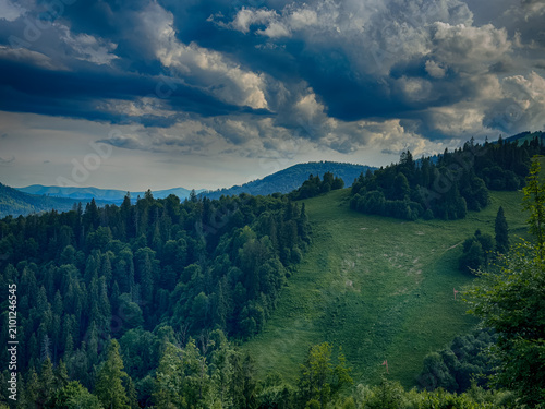 Sunny Carpathian peaks: green valleys and cloudy skies.