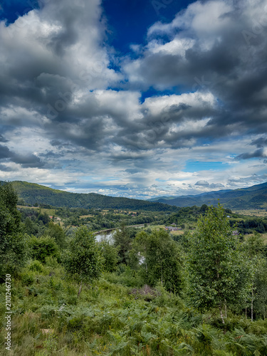 Sunny Carpathian peaks: green valleys and cloudy skies.