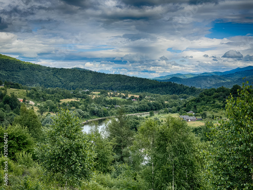 Sunny Carpathian peaks: green valleys and cloudy skies.
