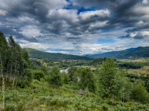 Sunny Carpathian peaks: green valleys and cloudy skies.