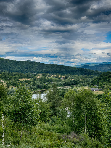 Sunny Carpathian peaks: green valleys and cloudy skies.