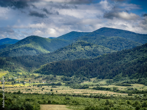 Sunny Carpathian peaks: green valleys and cloudy skies.