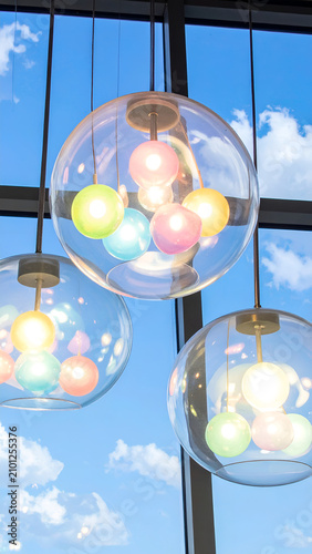 Colorful Orb Lights Suspended Against a Bright Blue Sky with Clouds.